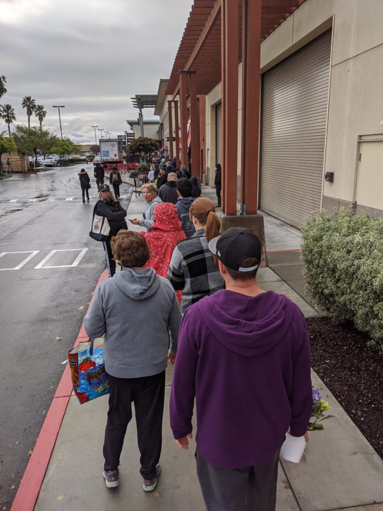 Line of people standing outside Trader Joe's in Alameda, CA