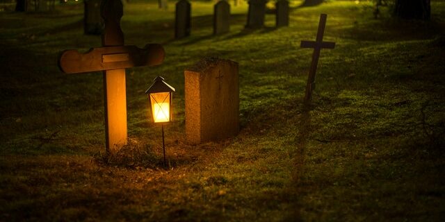 A lantern next to a tombstone