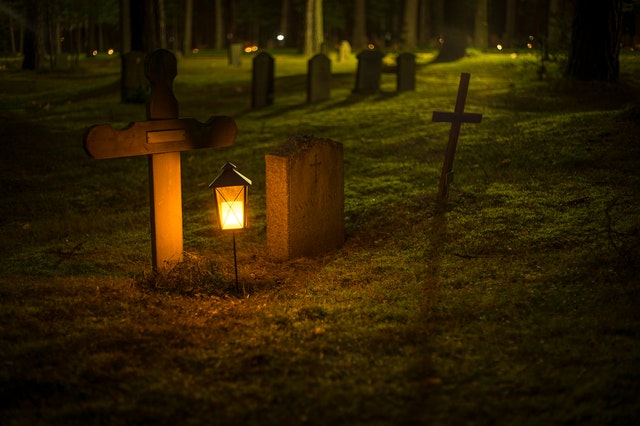 A lantern next to a tombstone